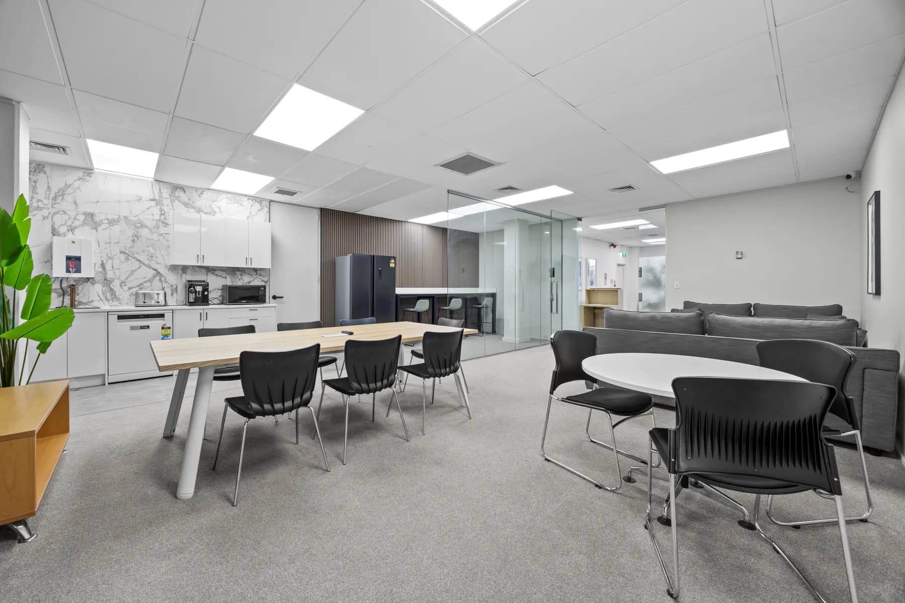 Shared kitchen, dining tables, and breakout lounge at Office.101 Penrose