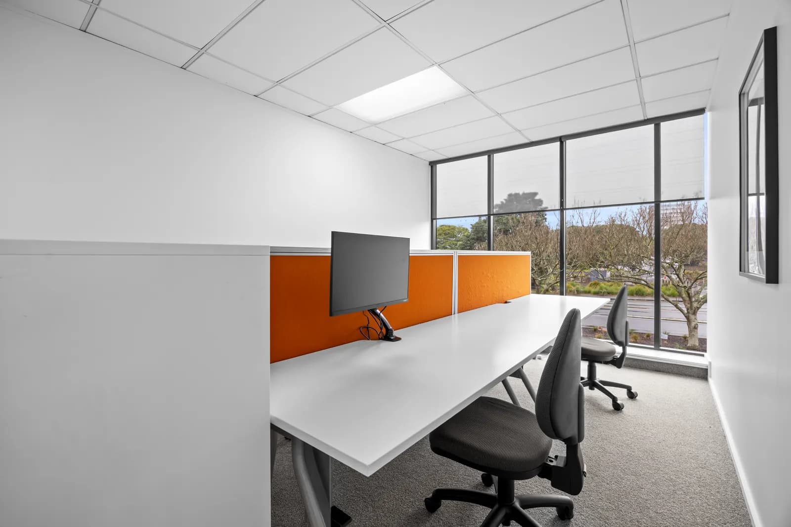 Dedicated desk with natural light and orange privacy screens